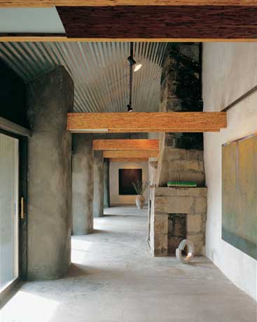 The home’s beautifully handcrafted stone fireplace is a stunning sculptural backdrop for Bennett’s own sculpture, left, and acrylic painting titled, First Mystery, above.
